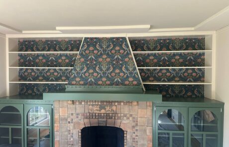 Decorative Wallpaper Installation on Fireplace Built In Shelves Expert wallpaper installation showcasing a beautiful bird and floral pattern on built in shelves above a fireplace.