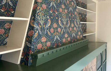 Professional Interior Painting and Wallpaper Installation for Living Room Freshly painted dark green fireplace mantel and built in shelves with elegant bird and floral patterned wallpaper.