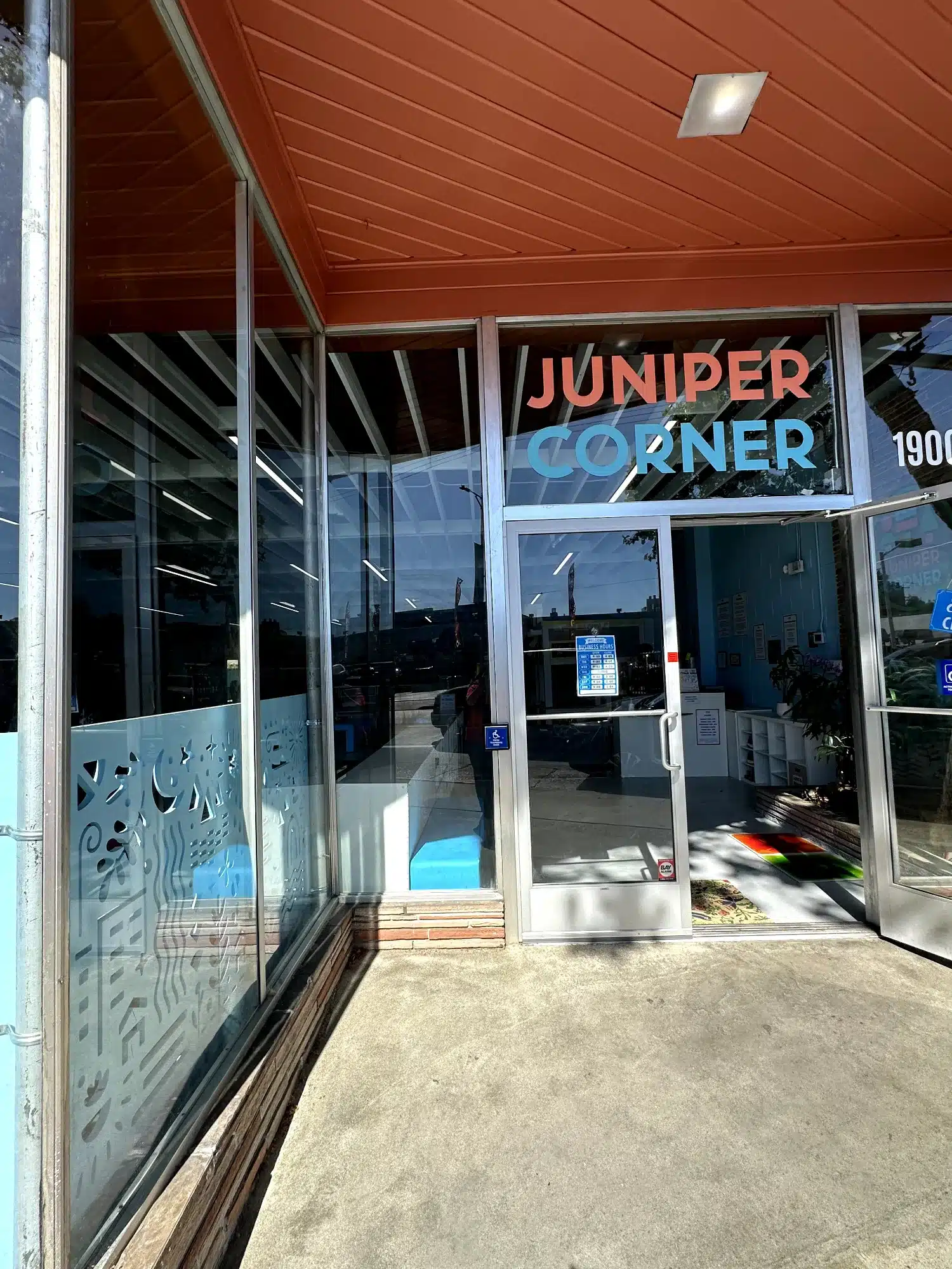 Commercial Storefront Window Decals Oakland Commercial storefront with light blue decorative window film featuring wave patterns, white aluminum framing, and rust-red