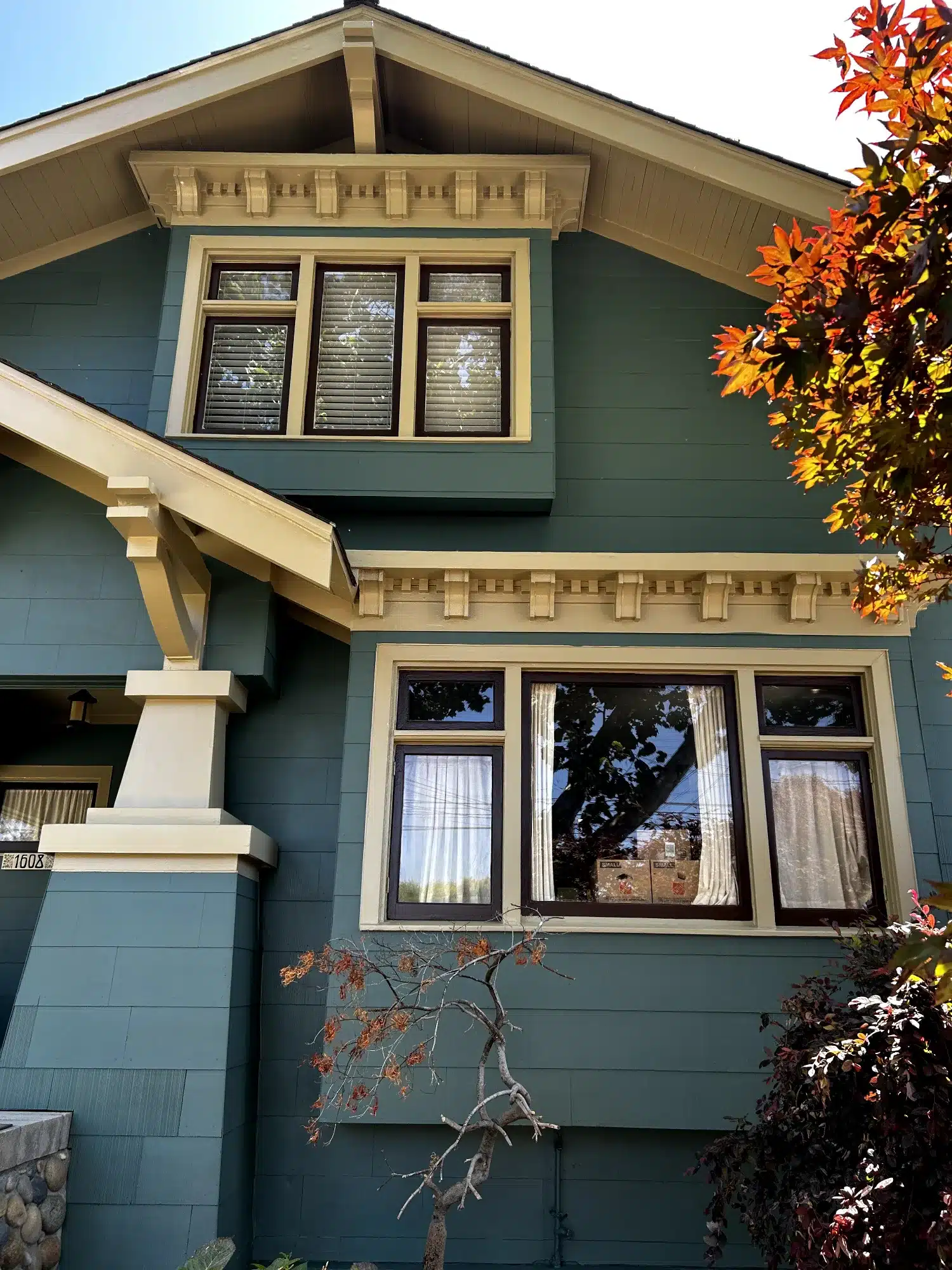 Teal Exterior Residential Home Teal-painted two-story residential exterior with cream trim, dark-framed windows, and decorative corbels in Oakland, CA